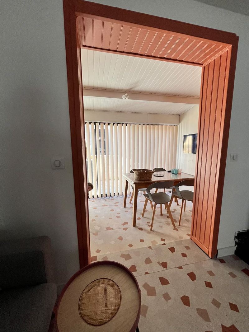 Porte terracotta ouvrant sur le séjour